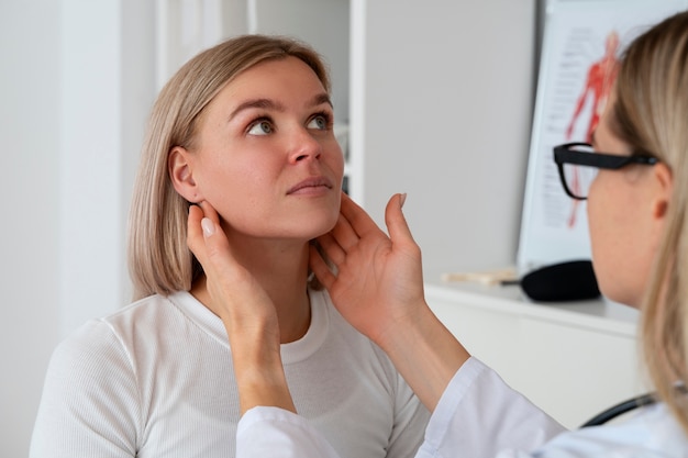 Kostenloses Foto seitenansichtdoktor, der frau überprüft