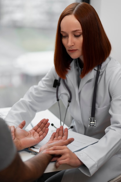 Kostenloses Foto seitenansichtdoktor, der patienten überprüft