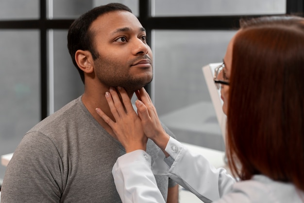 Kostenloses Foto seitenansichtdoktor, der patienten überprüft