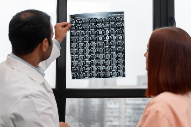 Kostenloses Foto seitenansichtdoktor, der radiographie hält