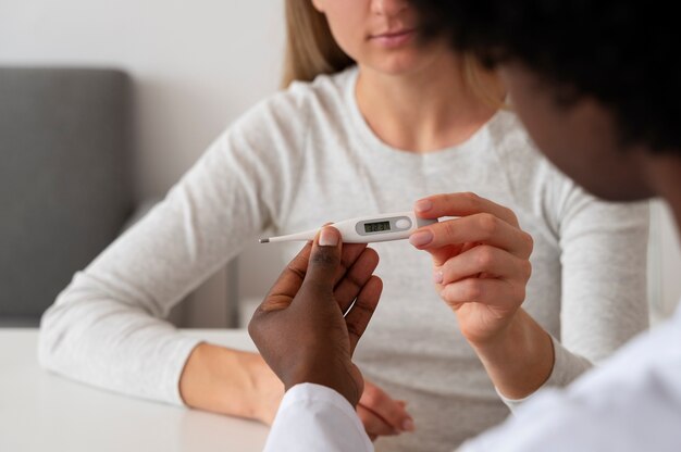 Seitenansichtdoktor, der thermometer hält