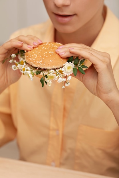 Kostenloses Foto seitenansichterwachsener, der burger hält