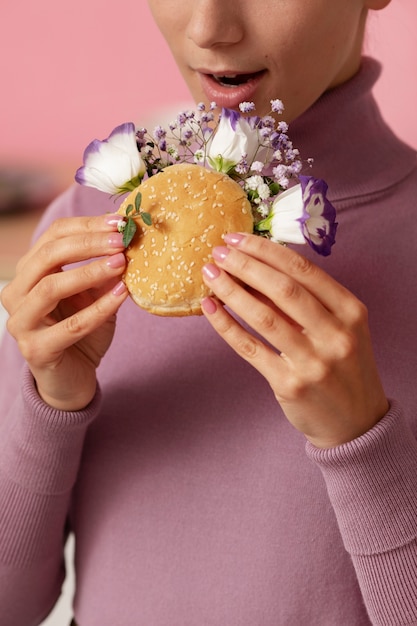 Seitenansichterwachsener, der Burger hält