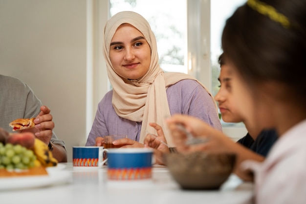 Seitenansichtfamilie, die am Tisch sitzt