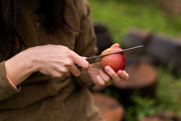 Seitenansichtfrau, die Apfel schneidet