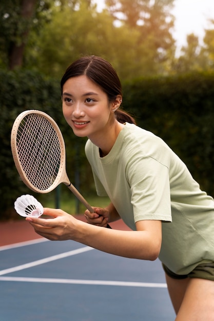 Seitenansichtfrau, die Badminton spielt