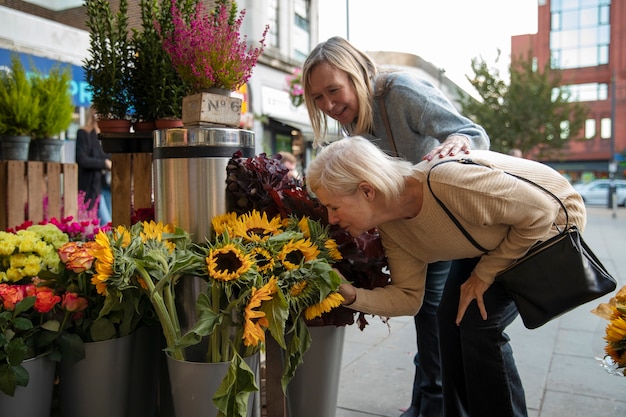 Seitenansichtfrau, die Blumen riecht