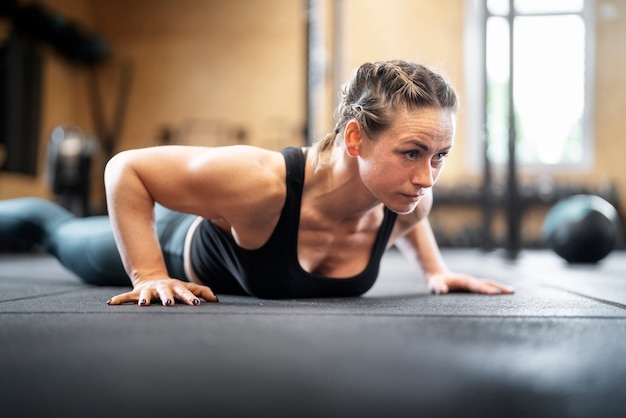 Seitenansichtfrau, die burpees tut