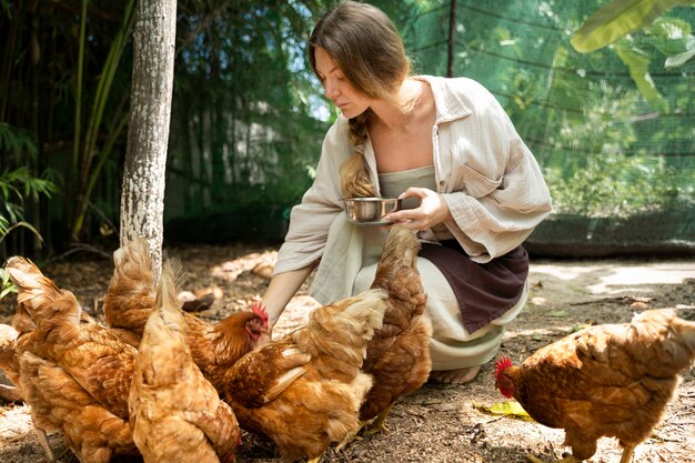 Seitenansichtfrau, die die Vögel füttert