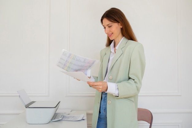 Seitenansichtfrau, die Drucker bei der Arbeit verwendet