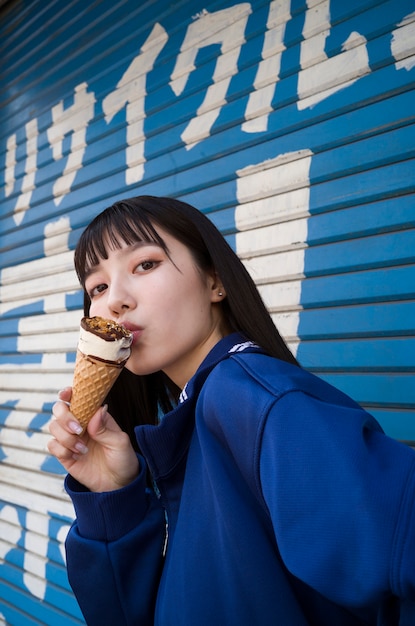 Kostenloses Foto seitenansichtfrau, die eiscreme isst