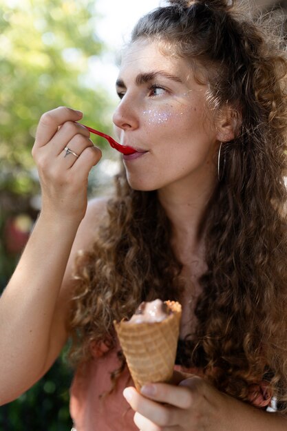 Seitenansichtfrau, die Eiscreme mit Löffel isst