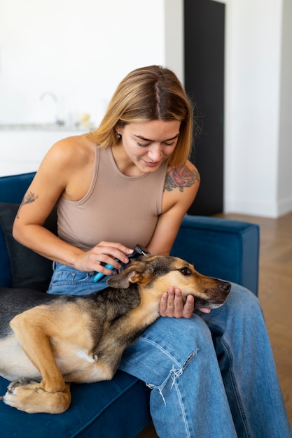 Kostenloses Foto seitenansichtfrau, die hund bürstet