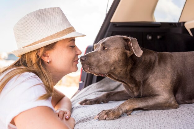 Seitenansichtfrau, die ihren Hund betrachtet