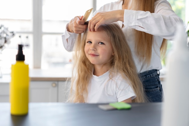 Seitenansichtfrau, die Mädchen mit Läusen hilft