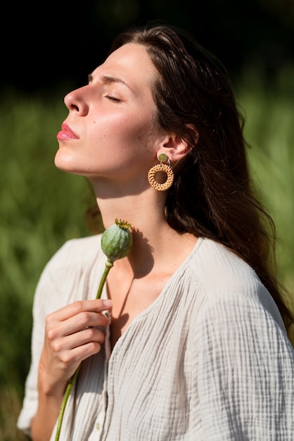 Kostenloses Foto seitenansichtfrau, die mit blume aufwirft