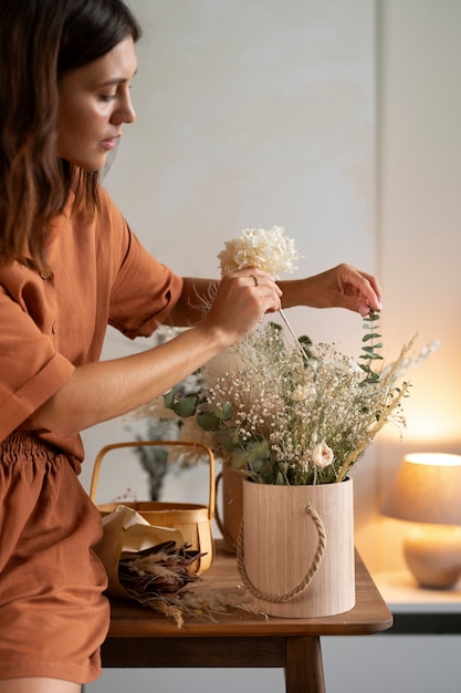 Seitenansichtfrau, die mit Blumen arbeitet