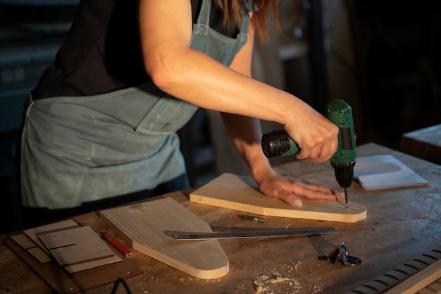 Seitenansichtfrau, die mit Holz arbeitet