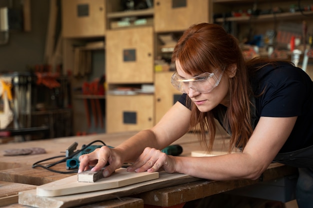 Seitenansichtfrau, die mit Holz arbeitet