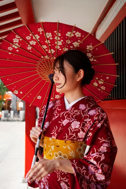 Seitenansichtfrau, die wagasa-regenschirm hält
