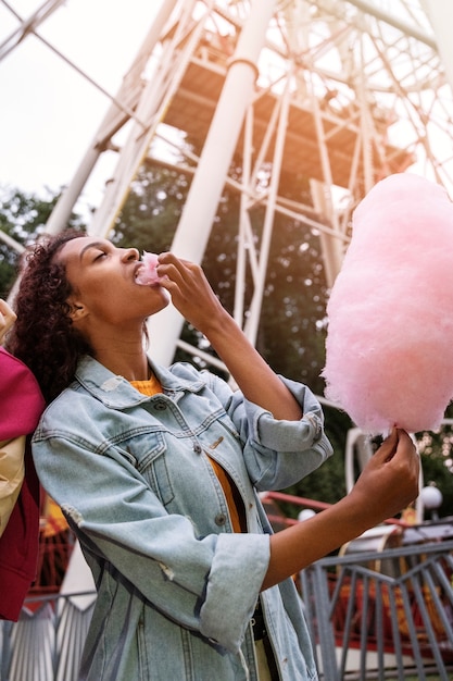 Seitenansichtfrau, die Zuckerwatte isst