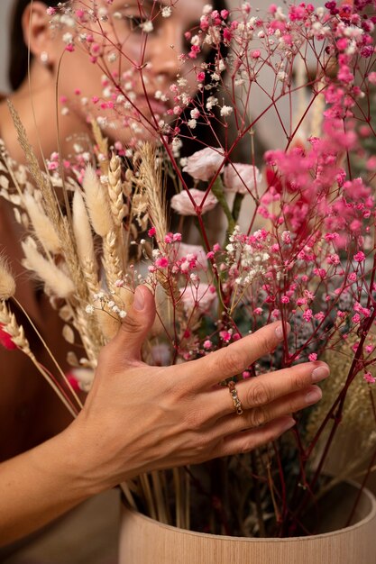 Kostenloses Foto seitenansichtfrau mit getrockneten blumen