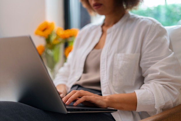 Kostenloses Foto seitenansichtfrau mit laptop und sonnenblumen