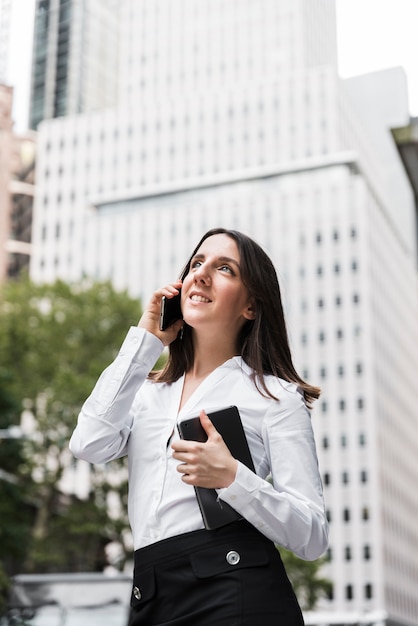 Seitenansichtfrau mit Tablette sprechend am Telefon