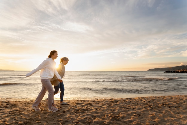 Kostenloses Foto seitenansichtfrauen, die auf strand gehen