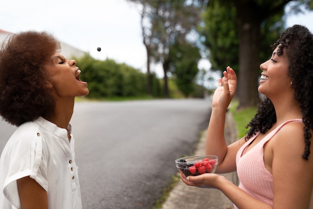 Kostenloses Foto seitenansichtfrauen, die beeren essen