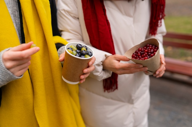 Kostenloses Foto seitenansichtfrauen, die beeren halten