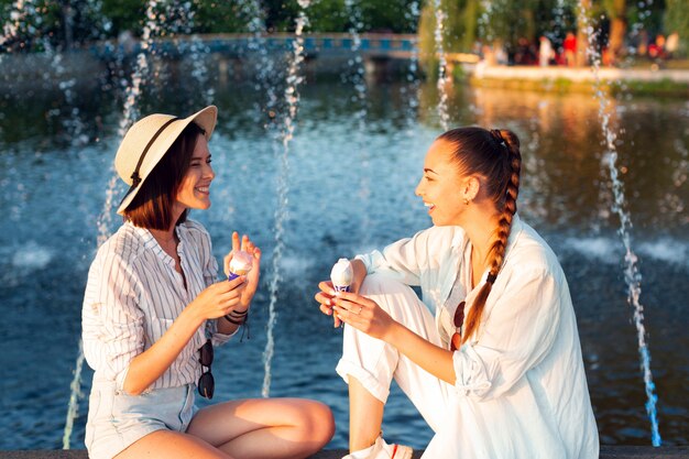 Seitenansichtfrauen, die heraus nahe bei Brunnen hängen