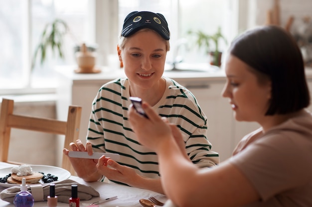 Kostenloses Foto seitenansichtfrauen, die maniküre erhalten