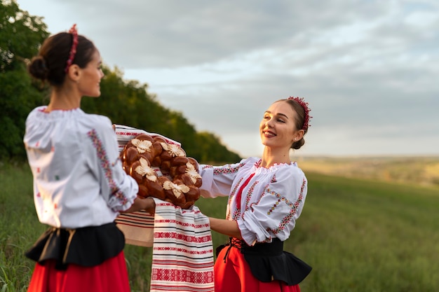 Kostenloses Foto seitenansichtfrauen, die mit kuchen tanzen