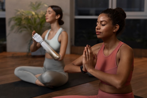 Seitenansichtfrauen, die zusammen Yoga machen
