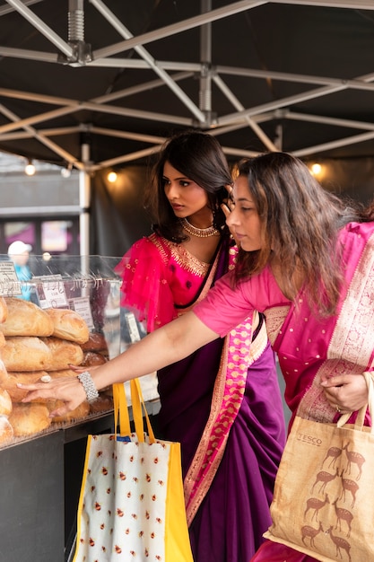 Seitenansichtfrauen mit sari-einkaufen