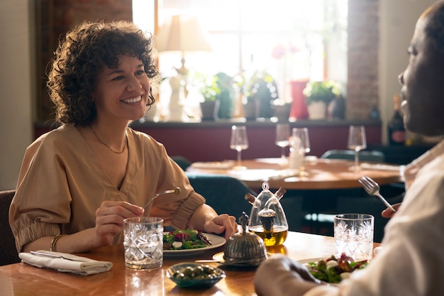 Kostenloses Foto seitenansichtfreunde, die im restaurant essen