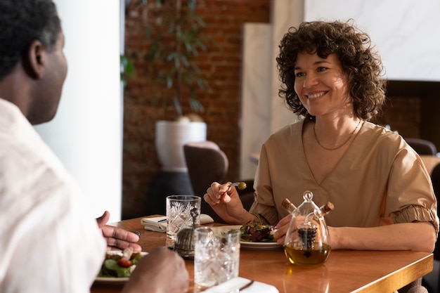 Kostenloses Foto seitenansichtfreunde, die im restaurant essen