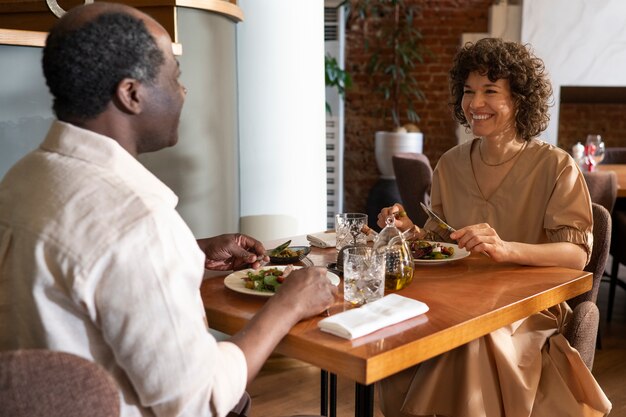 Seitenansichtfreunde, die im Restaurant essen