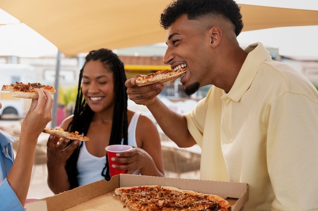 Seitenansichtfreunde, die pizza essen