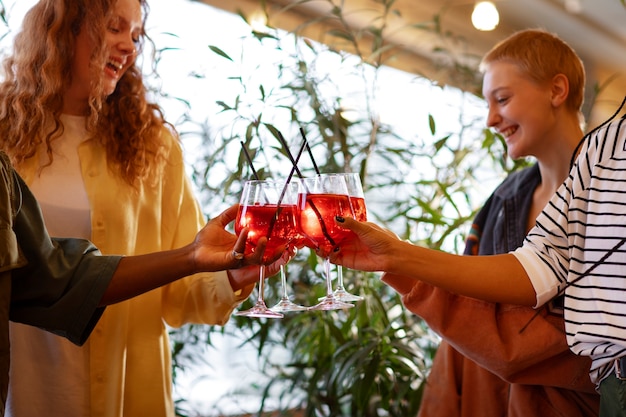 Kostenloses Foto seitenansichtfreunde mit köstlichen cocktails