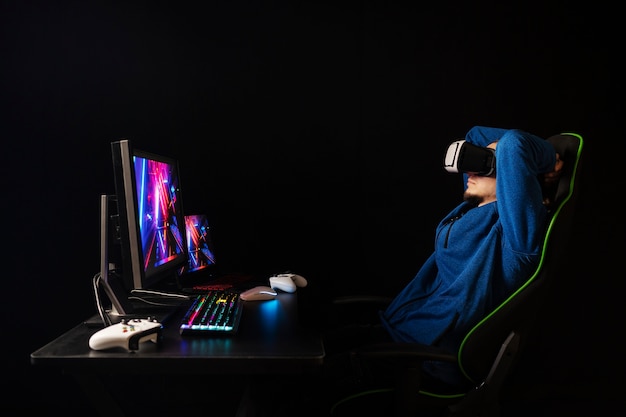 Seitenansichtgamer, der auf Stuhl sitzt