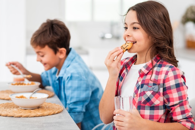 Kostenloses Foto seitenansichtgeschwister, die morgens frühstück essen