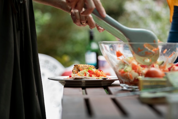 Seitenansichthände, die Salat mischen