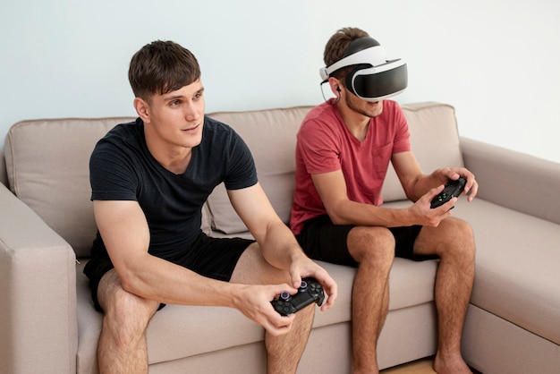 Seitenansichtjungen, die mit Prüfern und vr Gläsern spielen