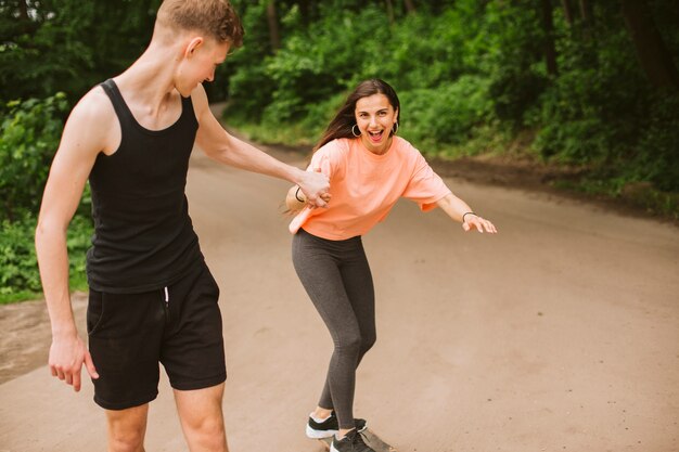 Seitenansichtkerl, der seinen Skateboard fahrenden Freunden hilft