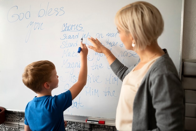 Seitenansichtkind, das auf whiteboard schreibt