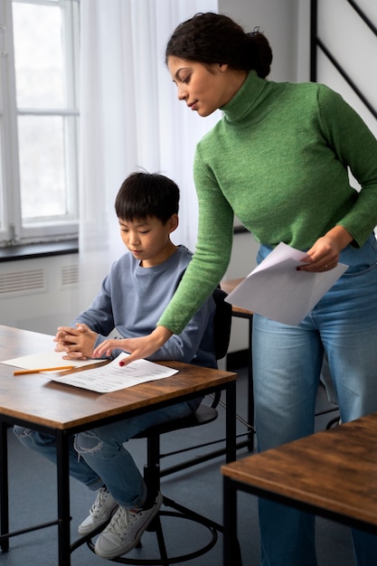 Kostenloses Foto seitenansichtkind, das beim schultest betrügt