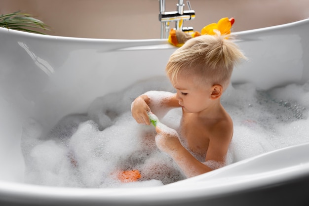 Seitenansichtkind, das in der Badewanne spielt