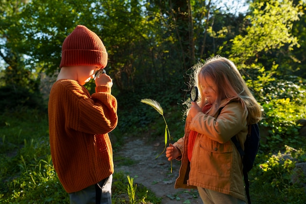 Kostenloses Foto seitenansichtkinder, die gemeinsam die natur erkunden